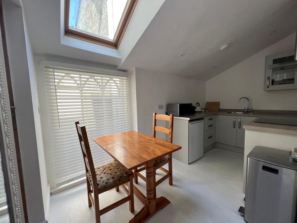 Lot: 144 - COMMERCIAL PROPERTY WITH THREE SELF-CONTAINED LETTING UNITS ENJOYING SEA VIEWS - Trispen - ground floor apartment kitchen dining room